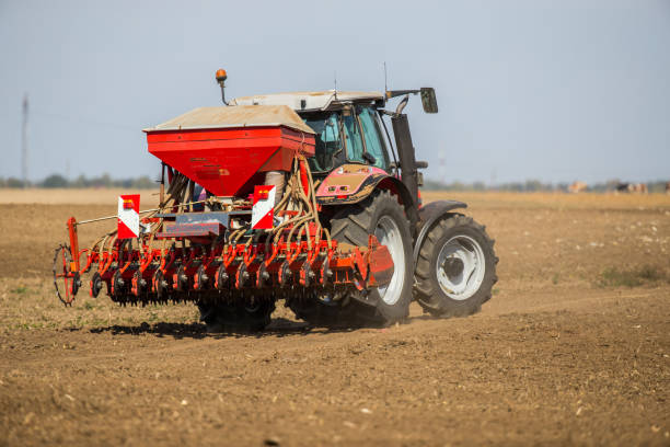 istock Farmer seeding, sowing crops at field. 974174778