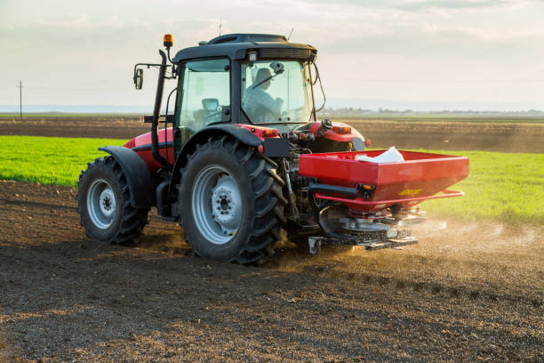 istock Farmer fertilizing arable land with nitrogen, phosphorus, potassium fertilizer 974174994