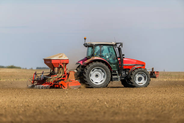 istock Farmer seeding, sowing crops at field. 974175208