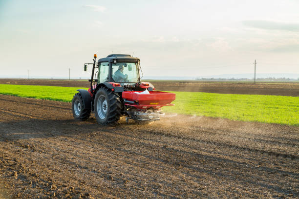 istock Farmer fertilizing arable land with nitrogen, phosphorus, potassium fertilizer 974178262