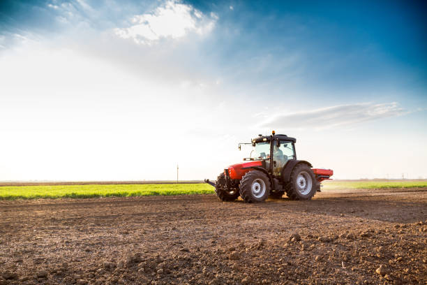istock Farmer fertilizing arable land with nitrogen, phosphorus, potassium fertilizer 974179174
