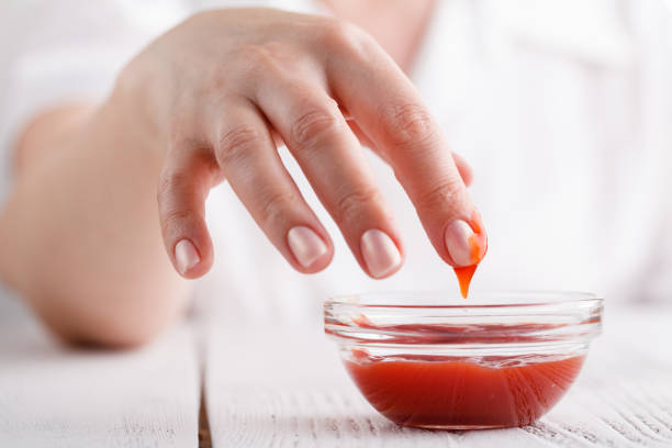 istock female dipping finger in tomato ketchup 974180326