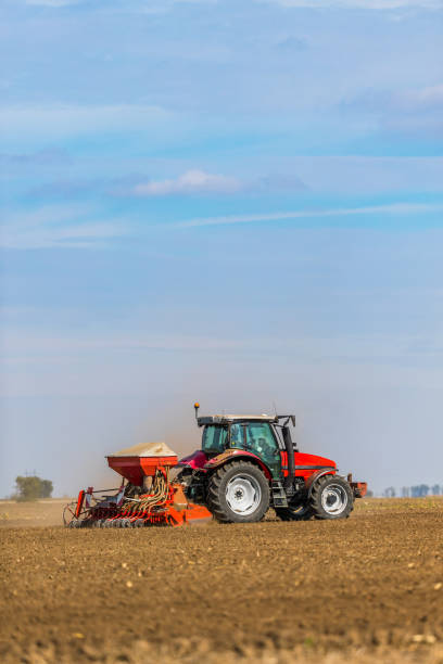 istock Farmer seeding, sowing crops at field. 974180440