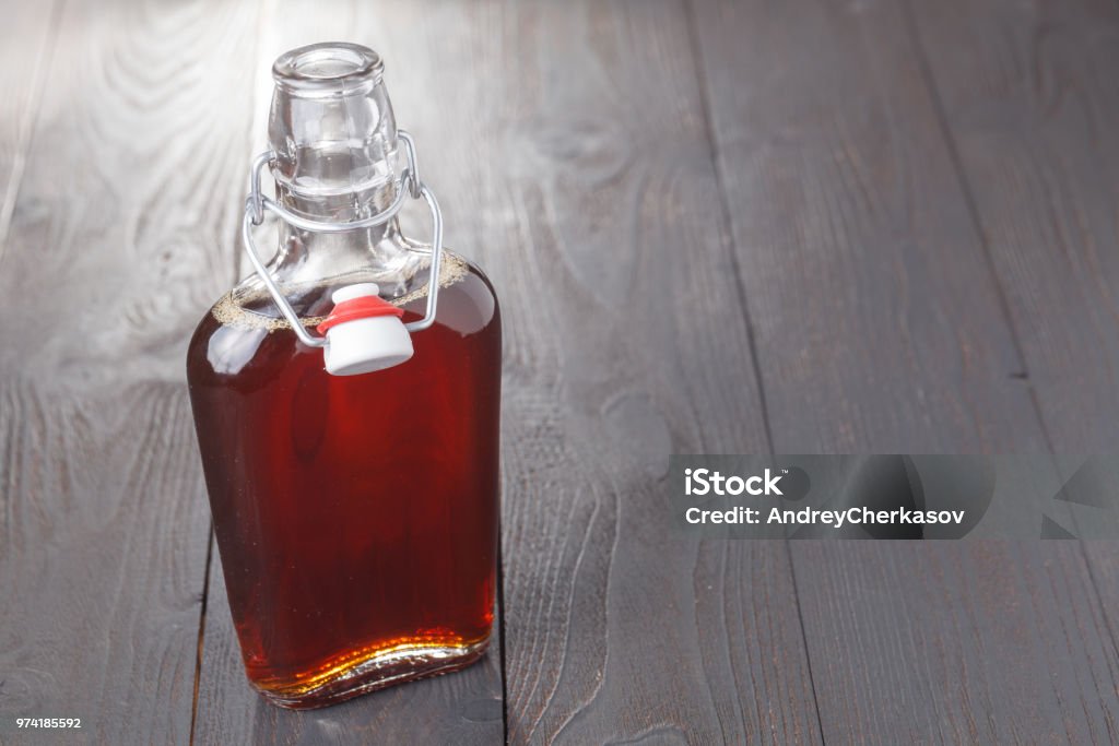 Homemade alcohol cordial drink in bottle on table Bottle Stock Photo