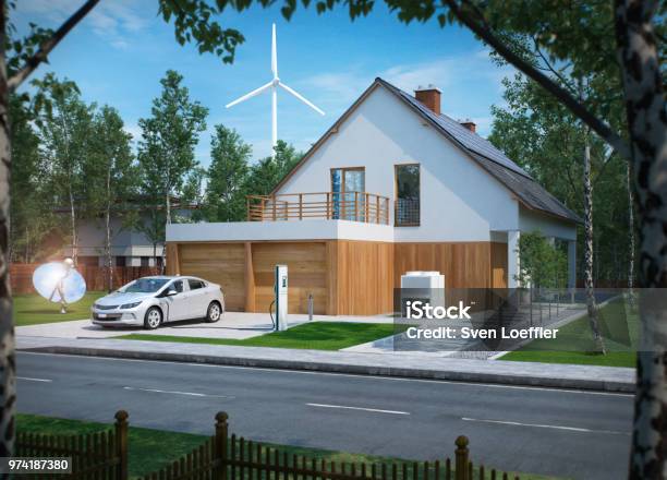 Home Electric Car Charging With Solar Power And Wind Power Turbine In The Background Stock Photo - Download Image Now