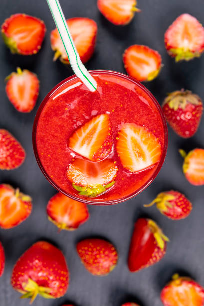 Strawberry in fresh smoothie on black table