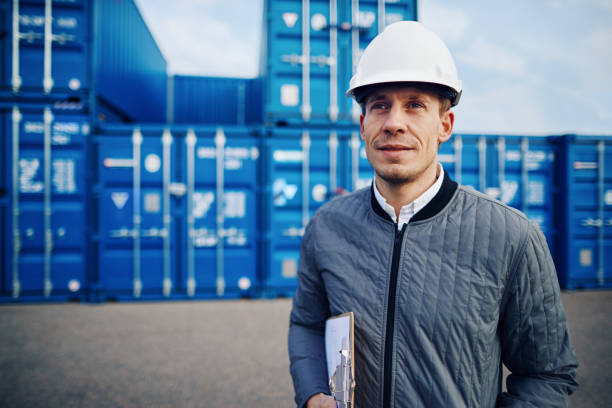 istock Smiling freight foreman standing on a large commercial shipping dock 974190846