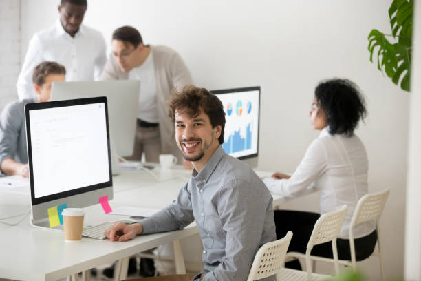 istock Smiling male worker looking at camera posing near office desk 974191836