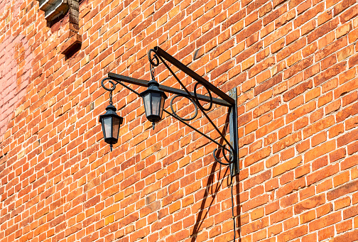 Vintage decorative lantern hanging on an old brick wall