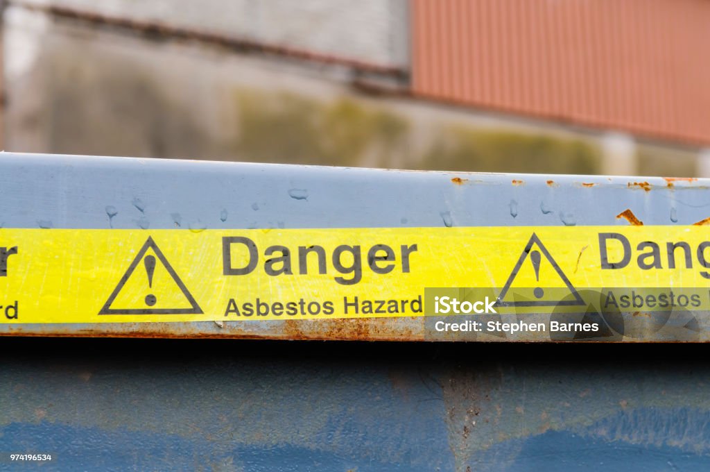 Warning tape across a bin at an Asbestos clean-up Asbestos Stock Photo