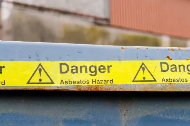 Photo of Warning tape across a bin at an Asbestos clean-up