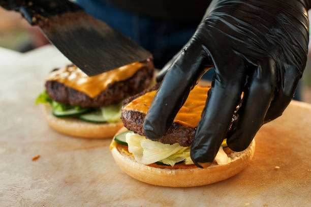 istock Chef making beef burger with cheese on open kitchen. Street fast food. 974199150