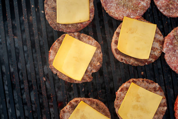 istock Beef cutlets with cheese on the grill. Top view. Strret food. 974199340