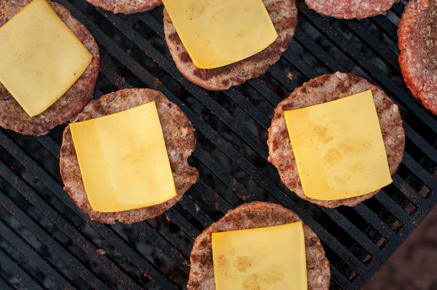 istock Beef cutlets with cheese on the grill. Top view. Strret food. 974199362