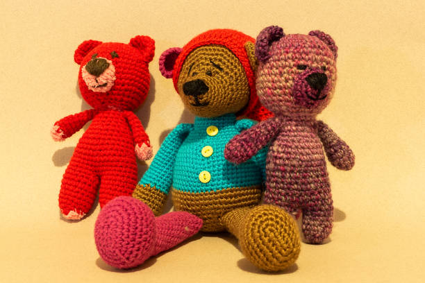 istock Handmade three colorful stuffed bear toy on yellow background. 974208636