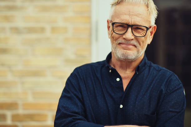istock Smiling senior man standing in his yard at home 974226684