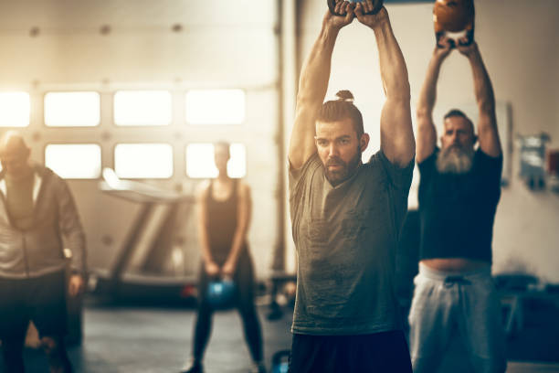 istock Fit people swinging weights during a gym exercise class 974232414