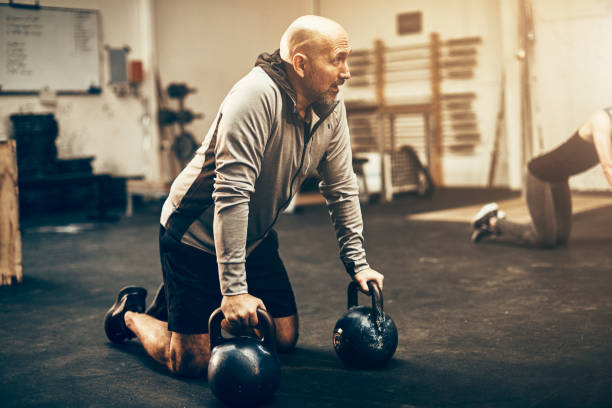 istock Mature man preparing to workout with dumbbells at the gym 974238302