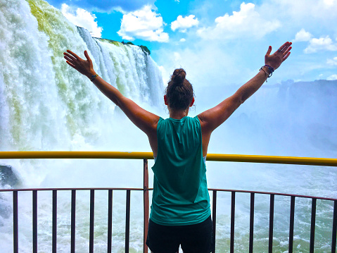 Arms outstretched close to the falls