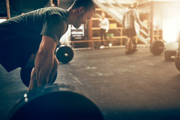 istock Young man preparing to lift weights during an exercise class 974238746