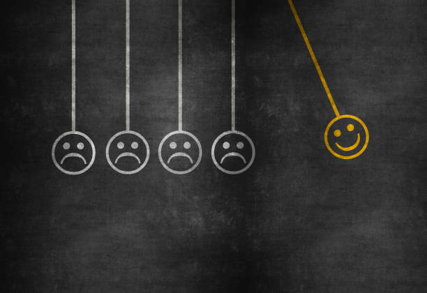 istock Happiness concept with happy and sad faces on newton’s cradle on blackboard 974239322
