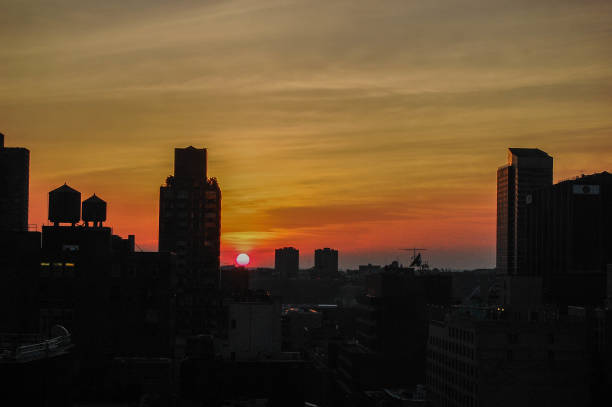 istock Orange Sunset Skies Over a New York Silhouette Skyline 974243784