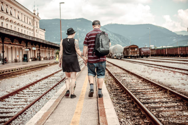 istock Young Millennial Couple Walking on Railroad Station 974248014