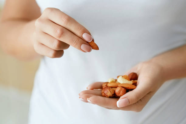 istock Close Up Of Nuts In Woman Hands. 974257316