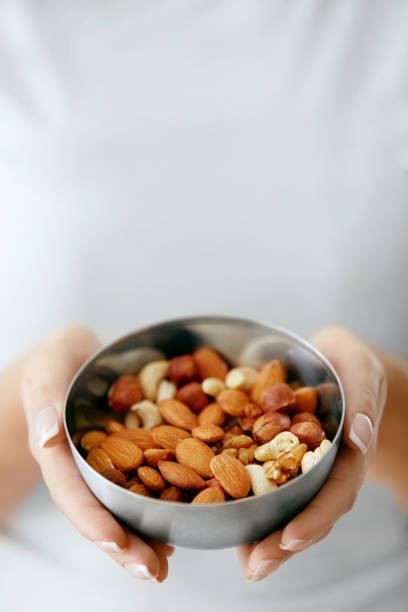 istock Healthy Food. Hands Holding Bowl With Nuts 974257358