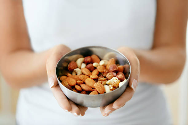 istock Healthy Food. Hands Holding Bowl With Nuts 974257376