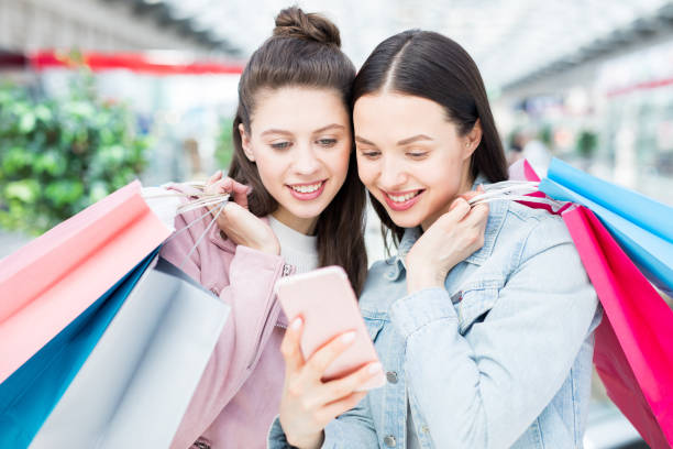 istock Cheerful girls using online shopping app 974257884