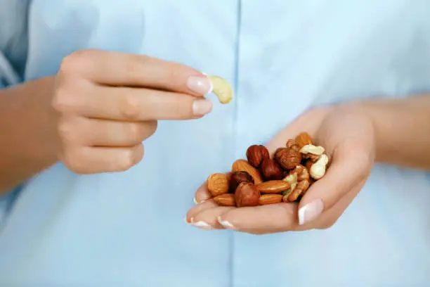 Close Up Of Nuts In Woman Hands. Female Holding Healthy Snacks. Healthy Lifestyle. Nutrition And Diet. High Quality Image.