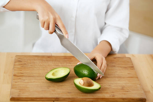 istock Diet. Female Hands Cutting Avocado In Kitchen. 974260676