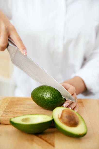 istock Diet. Female Hands Cutting Avocado In Kitchen. 974260866