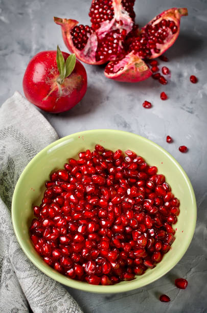 istock Red ripe pomegranate on gray concrete background 974265940