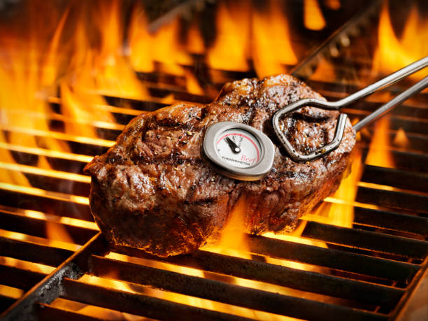 Closed bbq grill with the thermometer showing the temperature standing on the backyard.