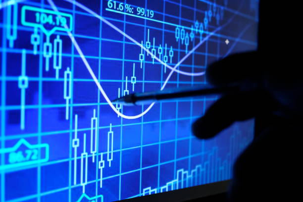 istock SHARE / FOREX / CRYPTO CURRENCY GRAPH WITH HAND HOLDING PEN AND SHOW TO THE GRAPH UNDER LOW LIGHT 974269356