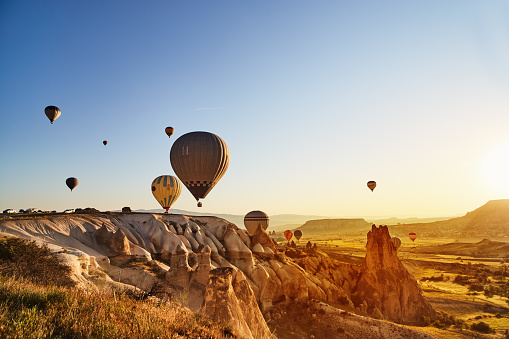 Globos de aire caliente vuelan al atardecer, Cappadocia, Turquía photo