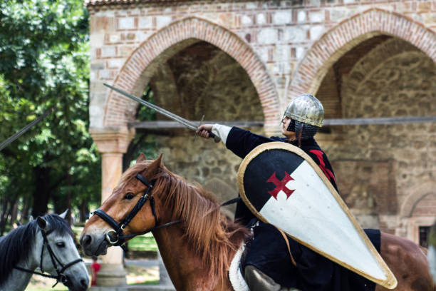 medieval knights posing on brown horse with armor, shield and sword - history knight historical reenactment military imagens e fotografias de stock