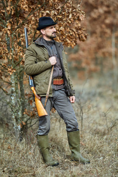istock Hunter with gun in the forest 974279494