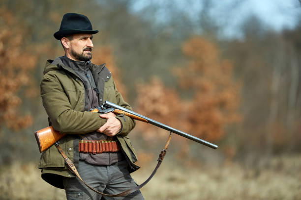 istock Hunter with gun in the forest 974279522