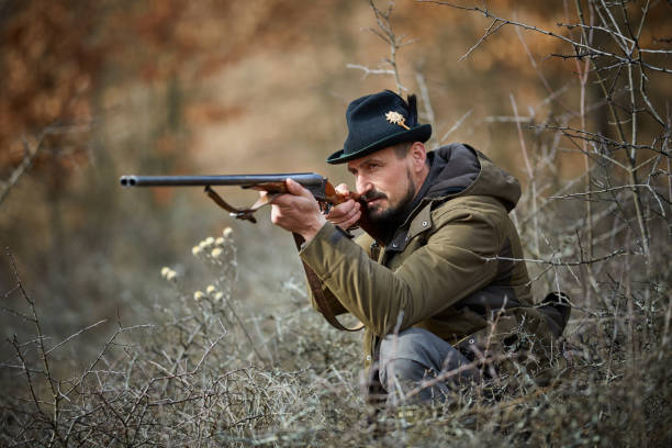 istock Hunter with gun in the forest 974279560