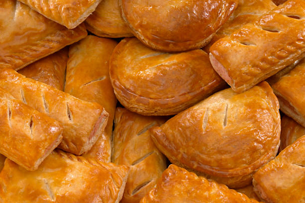 SELECTION OF SAVOURY PASTIES AND SAUSAGE ROLLS SELCTION OF FRESHLY BAKED SAVOURY PASTIES AND SAUSAGE ROLLS IN BAKERY sausage roll stock pictures, royalty-free photos & images