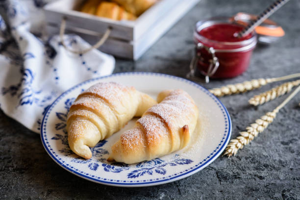 Freshly baked croissants served with raspberry jam and butter Traditional freshly baked croissants served with raspberry jam and butter sprinkling powdered sugar stock pictures, royalty-free photos & images