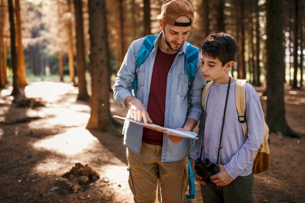 istock Father and son reading man in forest 974299672