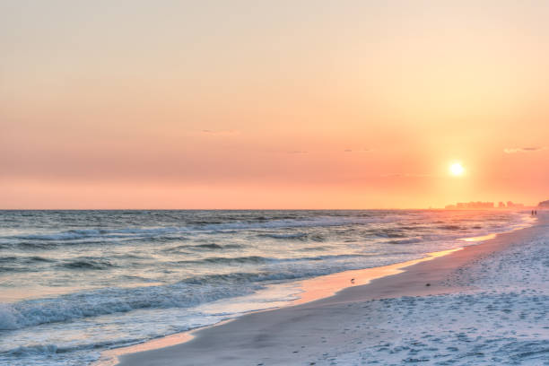 rêveuse rose pêche orange coucher de soleil à santa rosa beach, en floride avec pensacola littoral côte paysage urbain ligne d’horizon dans l’enclave avec océan golfe vagues mexique, oiseaux - pensacola photos et images de collection