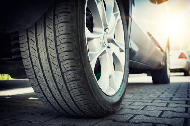 istock Car tire close up, parked car low angle shot 974329252