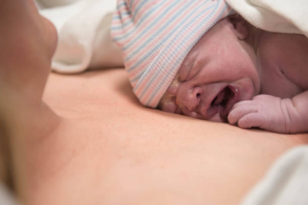 istock New born crying on mom's chest after birth 974363458