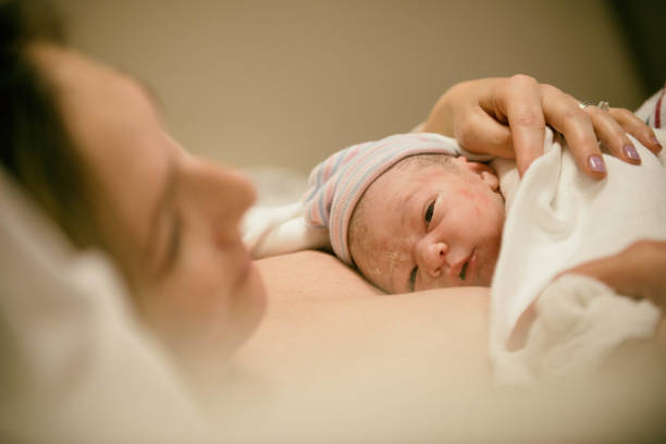 New born opening eyes for the first time after birth Young family birthing a baby in the hospital and enjoying baby's first few moments. delivering baby at home stock pictures, royalty-free photos & images
