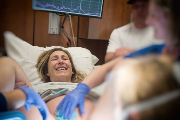 istock Mother laughing as she gives birth 974363480